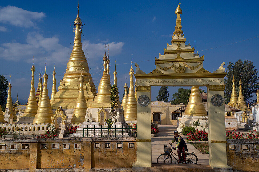 Fahrradfahrer in einem Tempel in Pindaya, Shan Staat, Myanmar, Burma