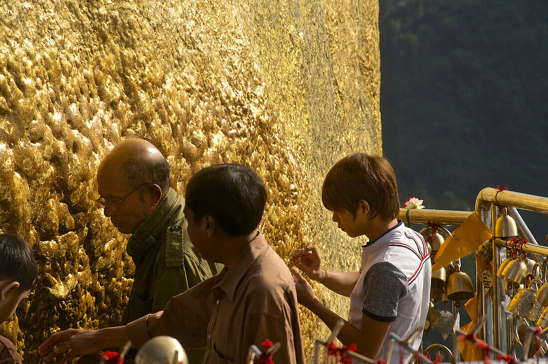 Burmesen bringen Blattgold am Goldenern Felsen an, Kyaikhtiyto Pagode, Mon State, Myanmar