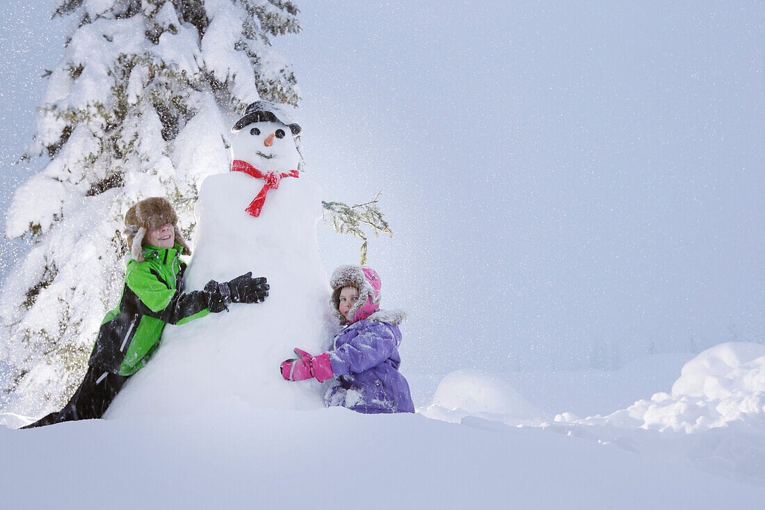 Children building a snowman, Passo Monte Croce di Comelico, South Tyrol, Italy