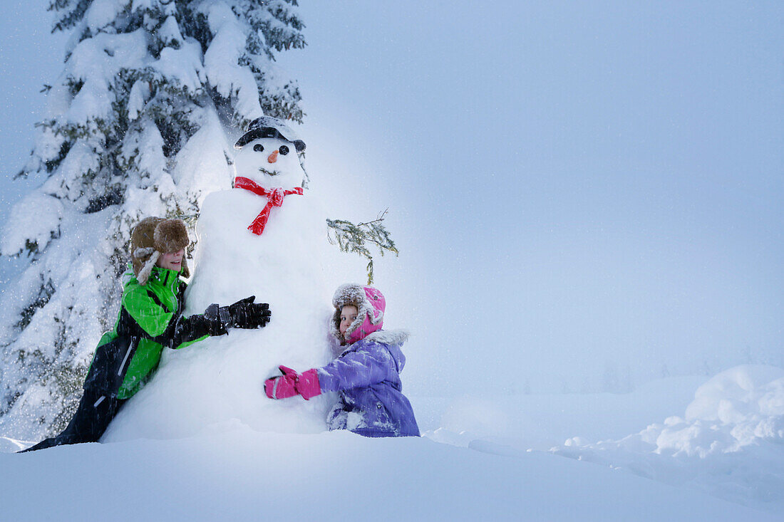 Kinder bauen einen Schneemann, Kreuzbergpass, Südtirol, Italien