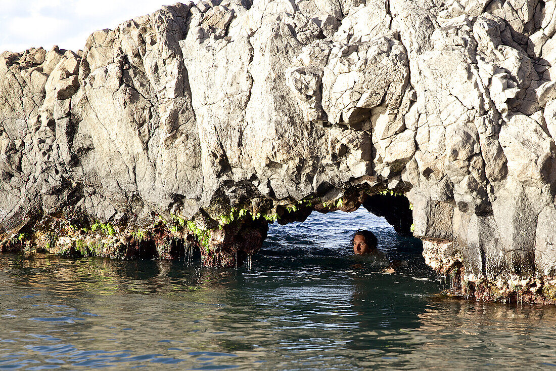 Mann badet unter einem Felsen, Praia, Santiago, Kap Verde