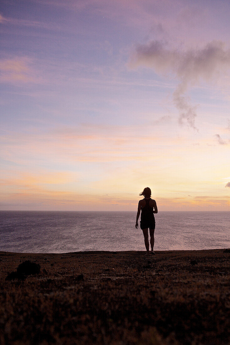 Frau betrachtet Sonnenuntergang über dem Meer, Praia, Santiago, Kap Verde