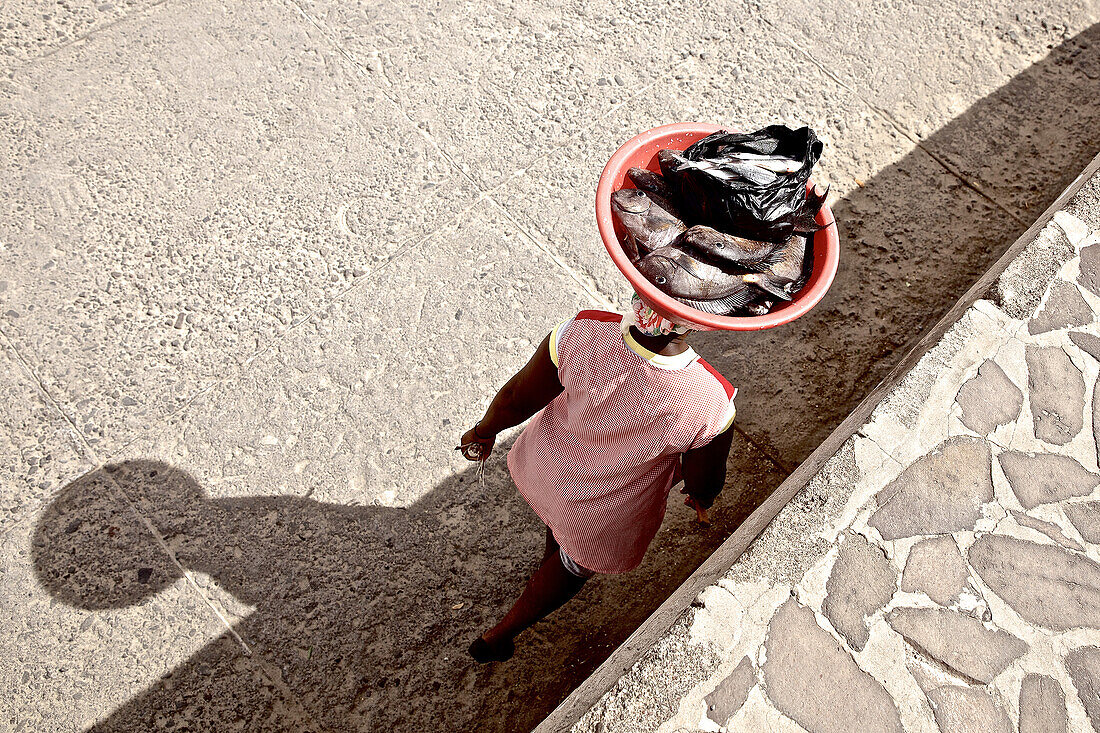 Woman carrying fish in a dish on her head, Praia, Santiago, Cape Verde