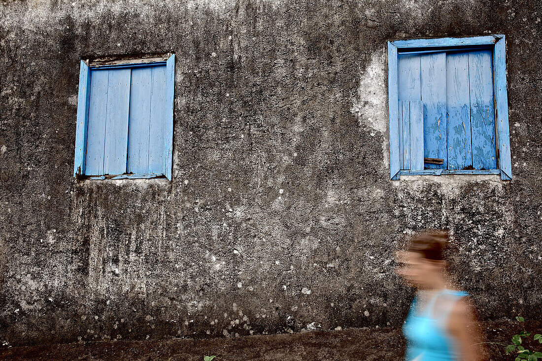 Young woman passing an old house, Praia, Santiago, Cape Verde