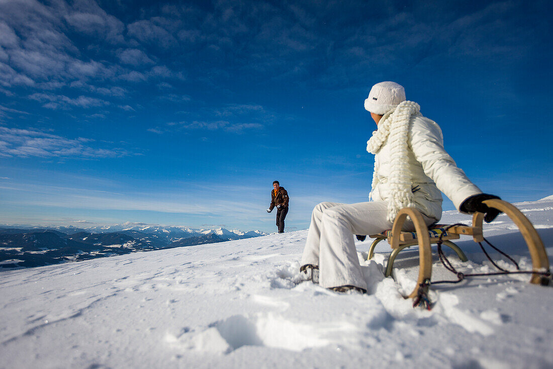 Paar mit Schlitten in Schnee, Mühlen, Steiermark, Österreich