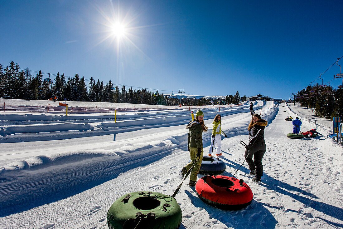 Junge Frauen mit Snowtubes am Kreischberg, Murau, Steiermark, Österreich