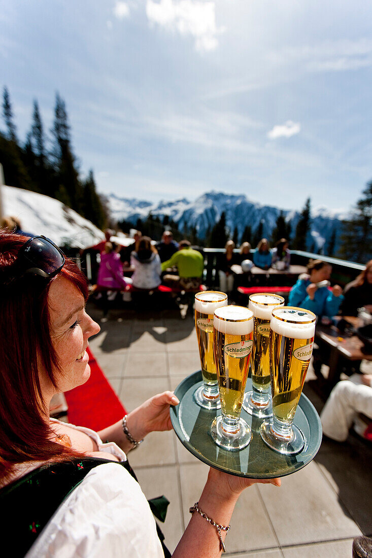 Waitress serving beers at ski hut terrace, Planai, Schladming, Styria, Austria