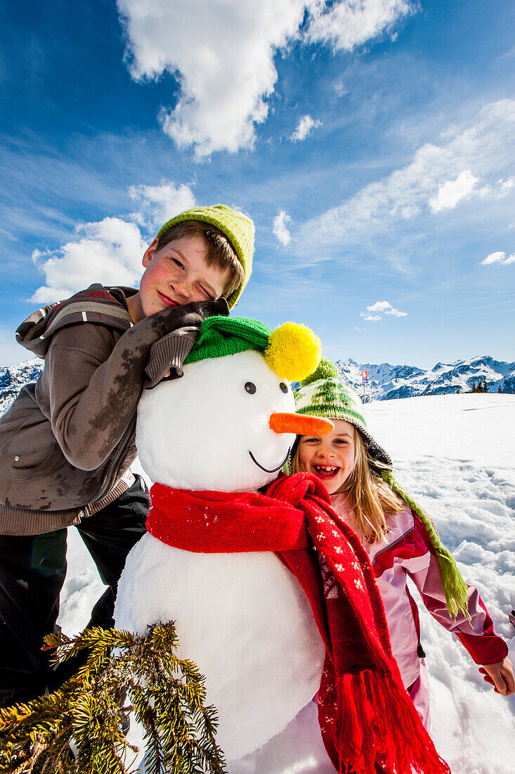 Zwei Kinder mit einem Schneemann, Planai, Schladming, Steiermark, Österreich