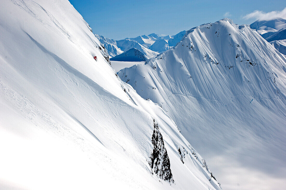 Skier downhill skiing in deep snow, Chugach Powder Guides, Girdwood, Alaska, USA