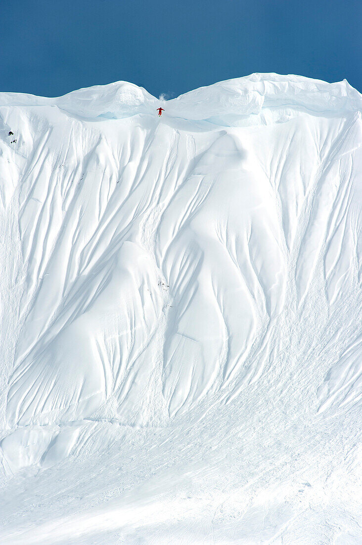 Skifahrer springt über Wechte, Chugach Powder Guides, Girdwood, Alaska, USA