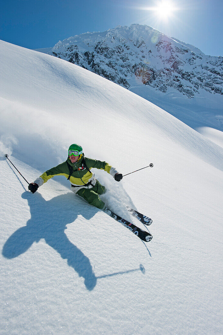 Skier downhill skiing in deep snow, Chugach Powder Guides, Girdwood, Alaska, USA