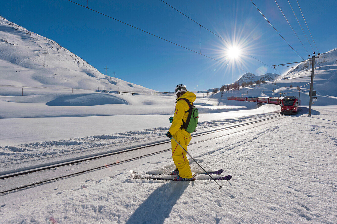 Skifahrer steht an Bahngleisen, Diavolezza, Oberengadin, Kanton Graubünden, Schweiz