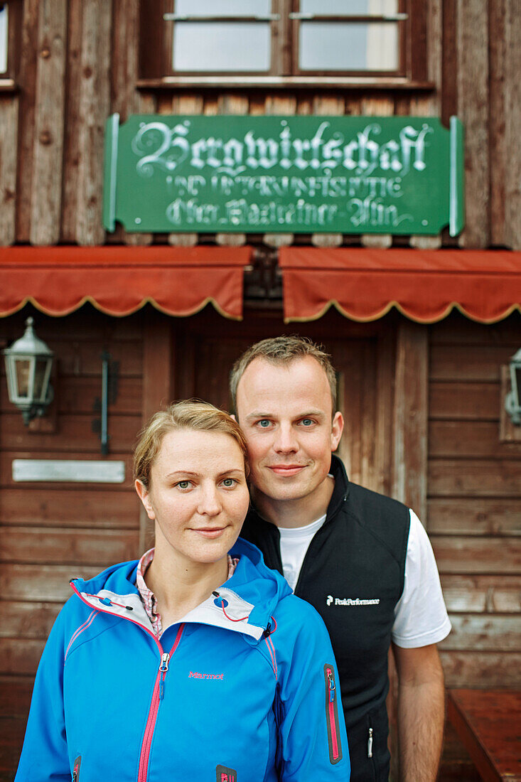 Couple in front of an alpine hut, Spitzingsee, Bavaria, Germany