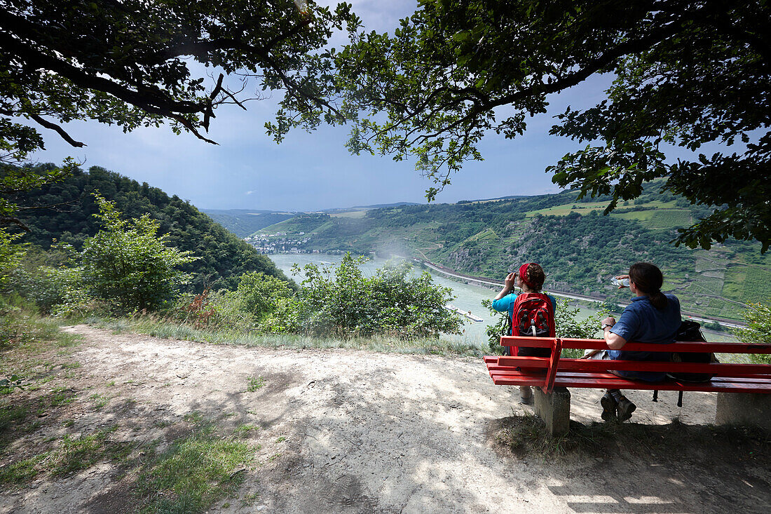 Hikers resting on a bench at view point Lennig, Bornich, Rhineland-Palatinate, Germany