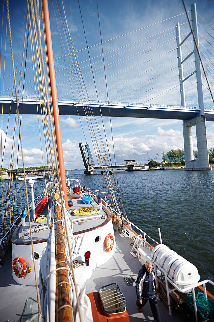 Segelschiff fährt in Hafen ein, Rügendamm und Rügenbrücke im Hintergrund, Stralsund, Mecklenburg-Vorpommern, Deutschland