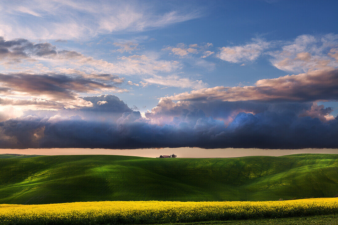 Pastures and fields in the tuscanian hills, under the clouds of a springtime sunset, Tuscany
