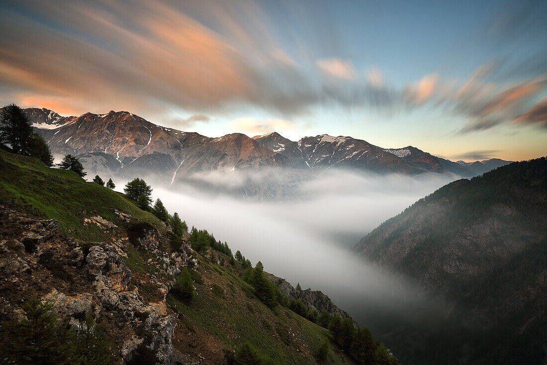 At the end of the afternoon clouds coming from the plane  reach the top of Alpine valley of southern Piemonte, Italy
