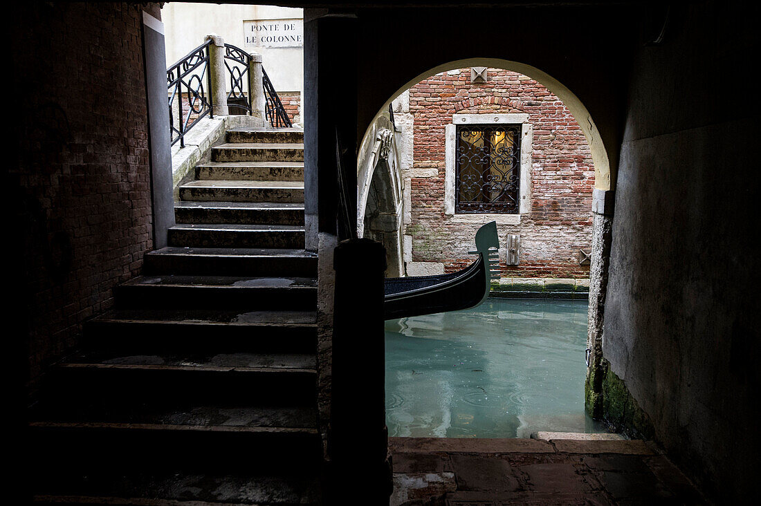 A typical venetian corner, with a pier on the canal and an old bridge, Venice, Italy