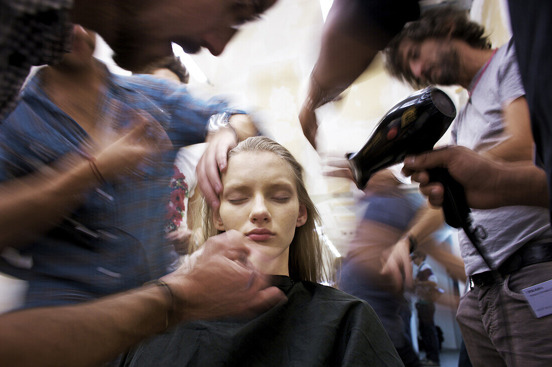 A model is prepared for a show at Prada during fashion week in Milan.