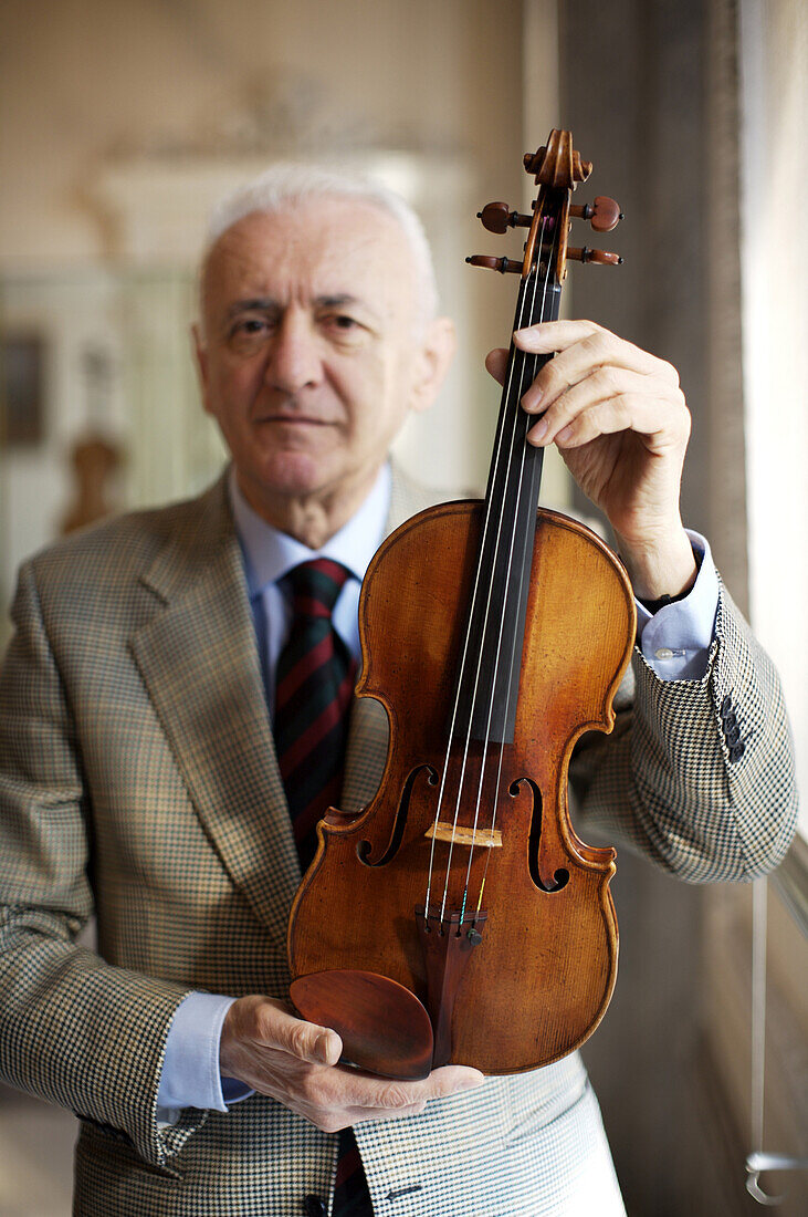'Mosconi holds ''Il Cremonese,'' Cremona's most important Stradivarius violin. ''Conservatore'' Andrea Mosconi maintains the city of Cremona's precious violin collection, many of them Stradivarius violins, by playing them for a few minutes each morning. C