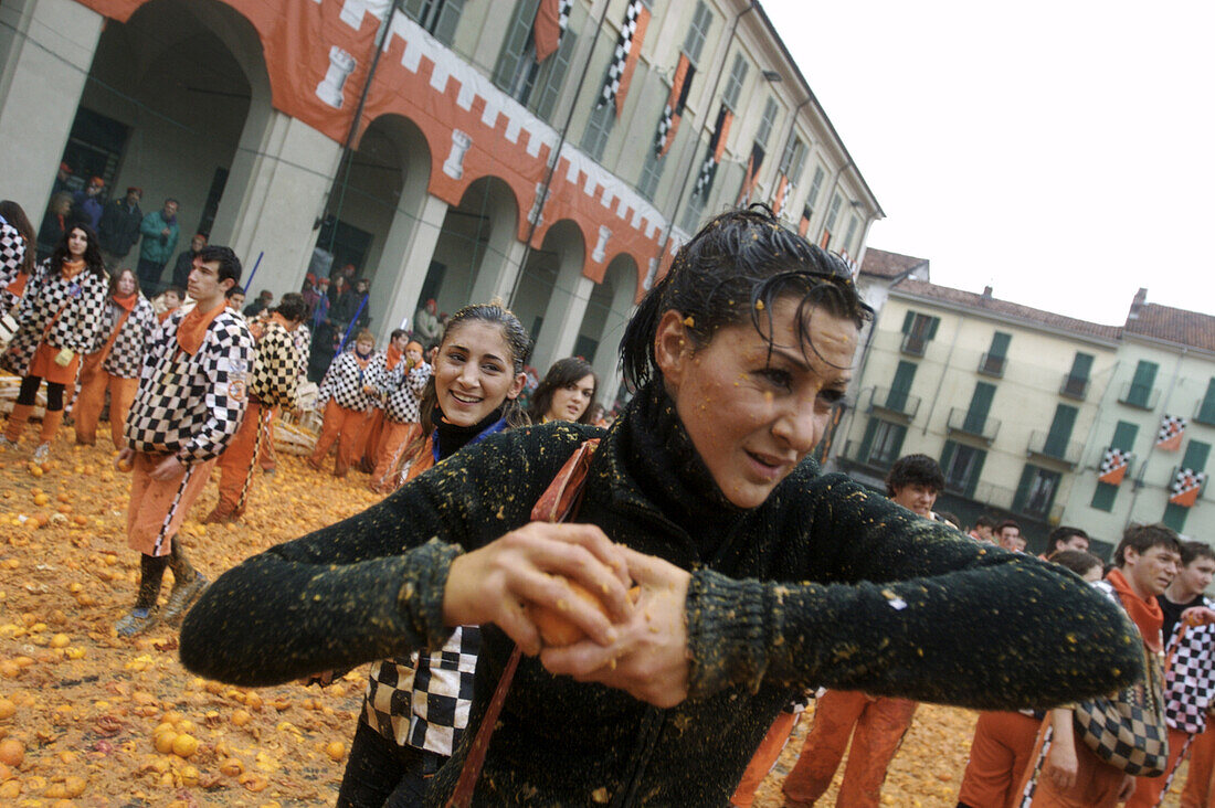 A woman attacks the opposition during the orange battles of Ivrea, Italy.