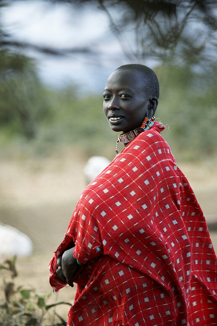 Masai people living in a small village, about 5 houses, at the foot of Mount Kilimanjaro in Kenya, 10 km from Amboseli National Park. They have traditional colorful clothes and decorations. The Masais are among the richest original people in Kenya, there 