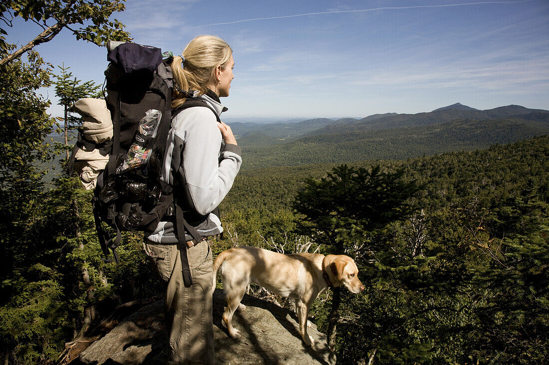 Mid adult woman hiking the Longtrail North at the summit of Mt. Abraham in Vermont, USA.