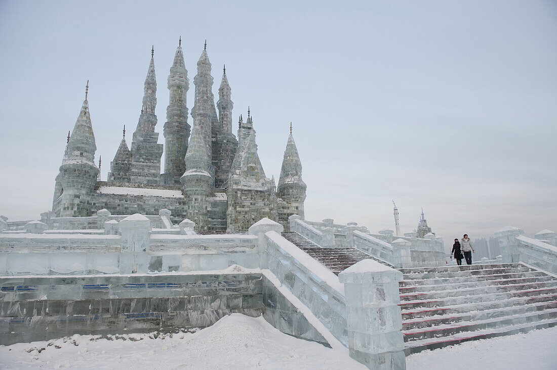 A couple of tourists walking on an ice replica of the Neuschwanstein castle in Harbin, China on January 17, 2009. The Harbin Ice and snow festivals is one of the world's biggest, and it covers an area of 400,000 square meters, with ice consumption at 120,