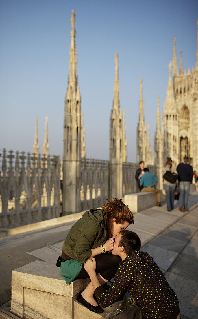 A couple kiss on the roof of Milan's Duomo.