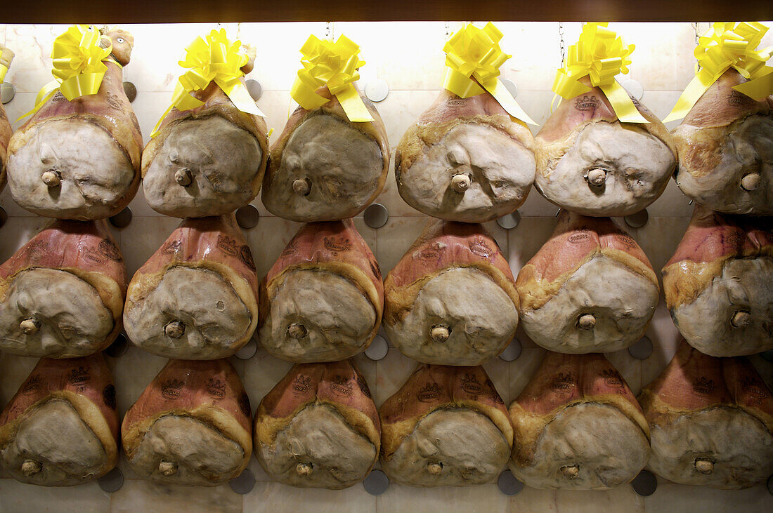 Legs of prosciutto line the walls at the food store Peck in Milan