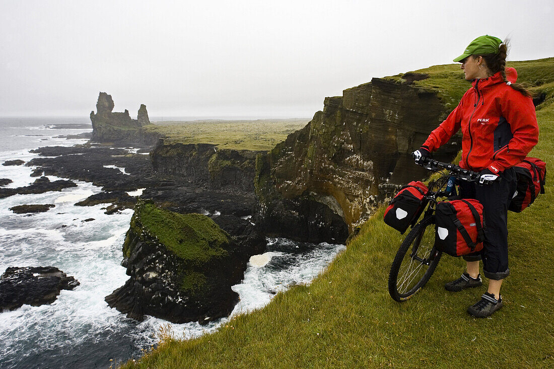 Myriam Rovere looks at the incredible landscape of the volcanic cliffs of the Snaefellsnes peninsula, along the mountain biking tour of Iceland.