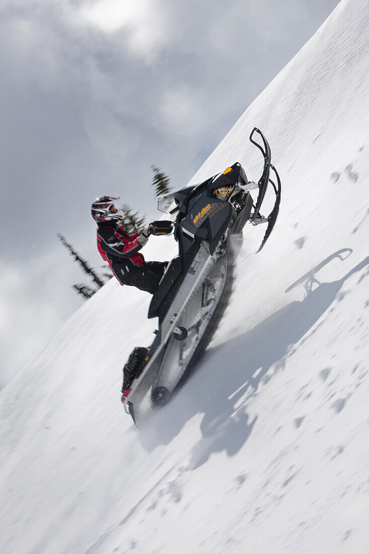 One man gets some air while riding on a snowmobile up the side of Owlshead Mountain above Sicamous in British Columbia, Canada.