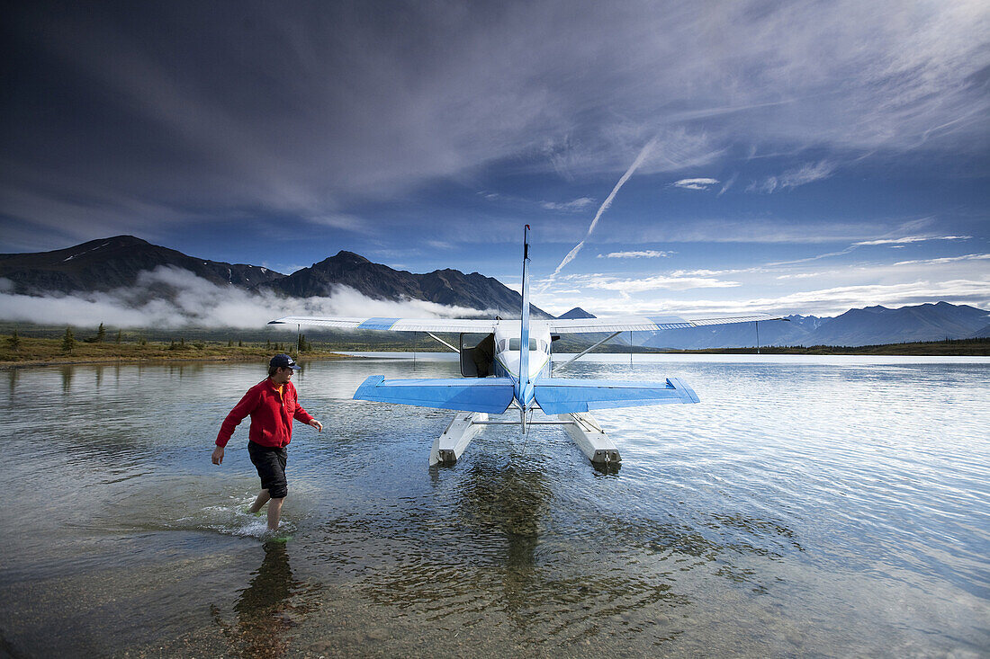 Joel Reynolds walks around a float plane in Twin Lakes in Lake Clark National Park, Alaska.