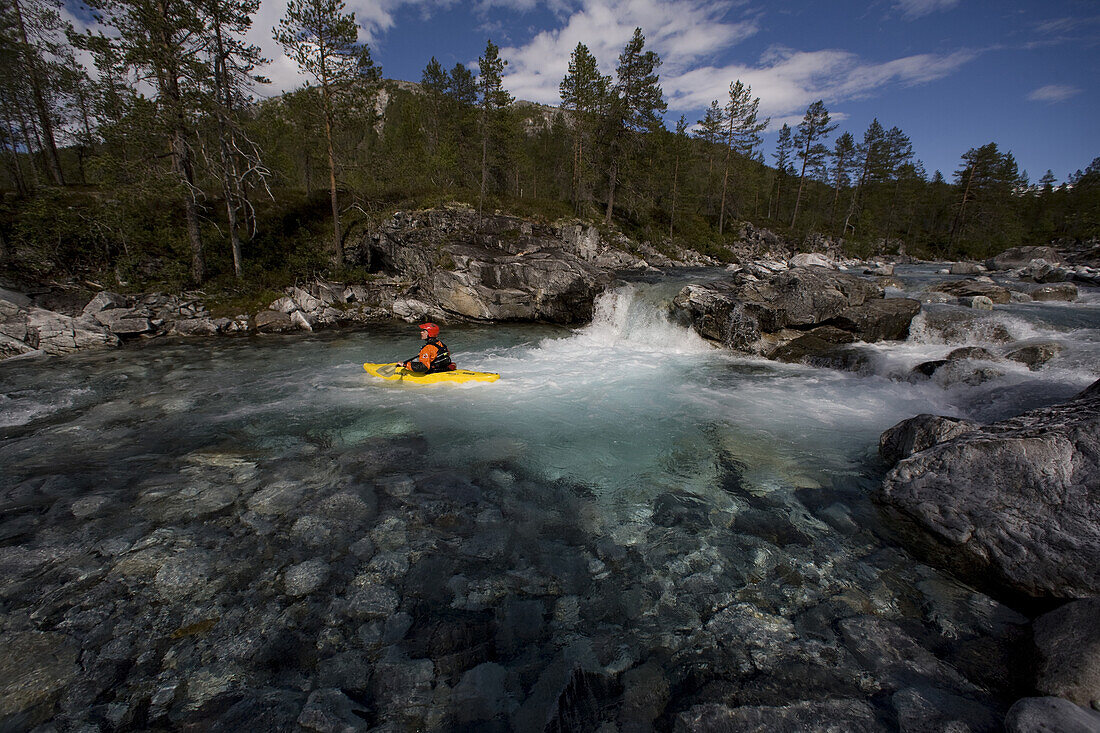 Christoph Schuhmacher red helmet,  enjoys a calm part of the water while kayaking on the Brandseht River. in the western part of Norway.