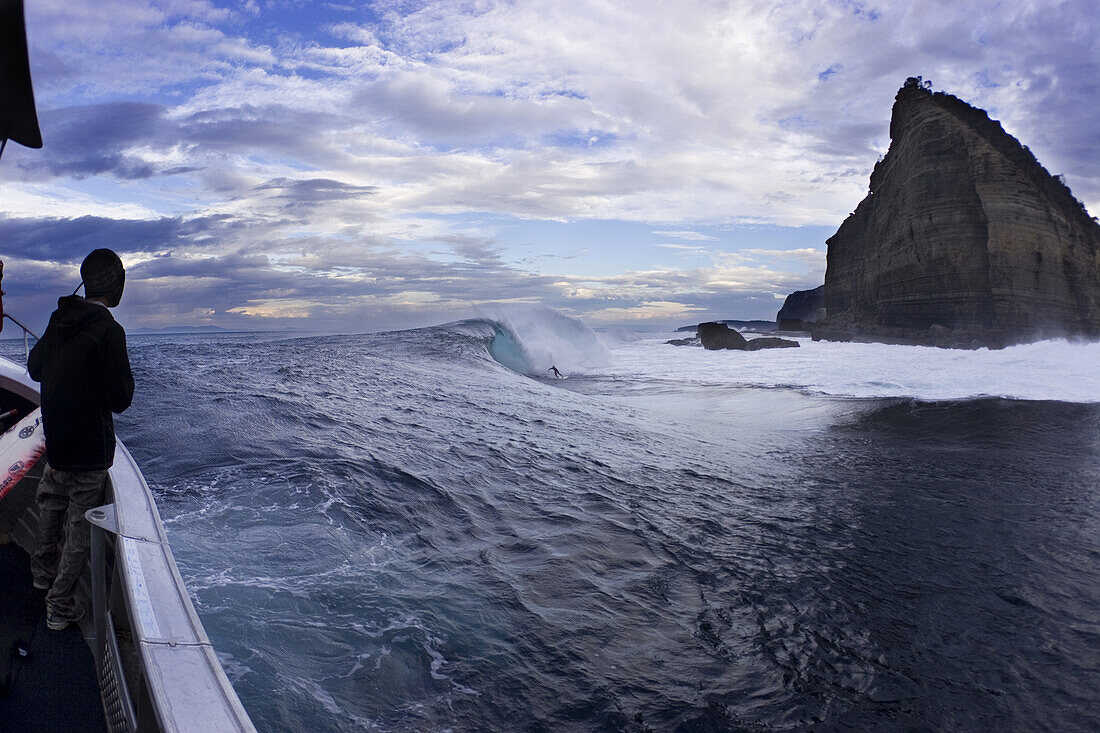 Marti Paradisis surfing at Shipsterns Bluff, while jeremy Sherwin watches on from the boat.  Tasmania, 03.23.07