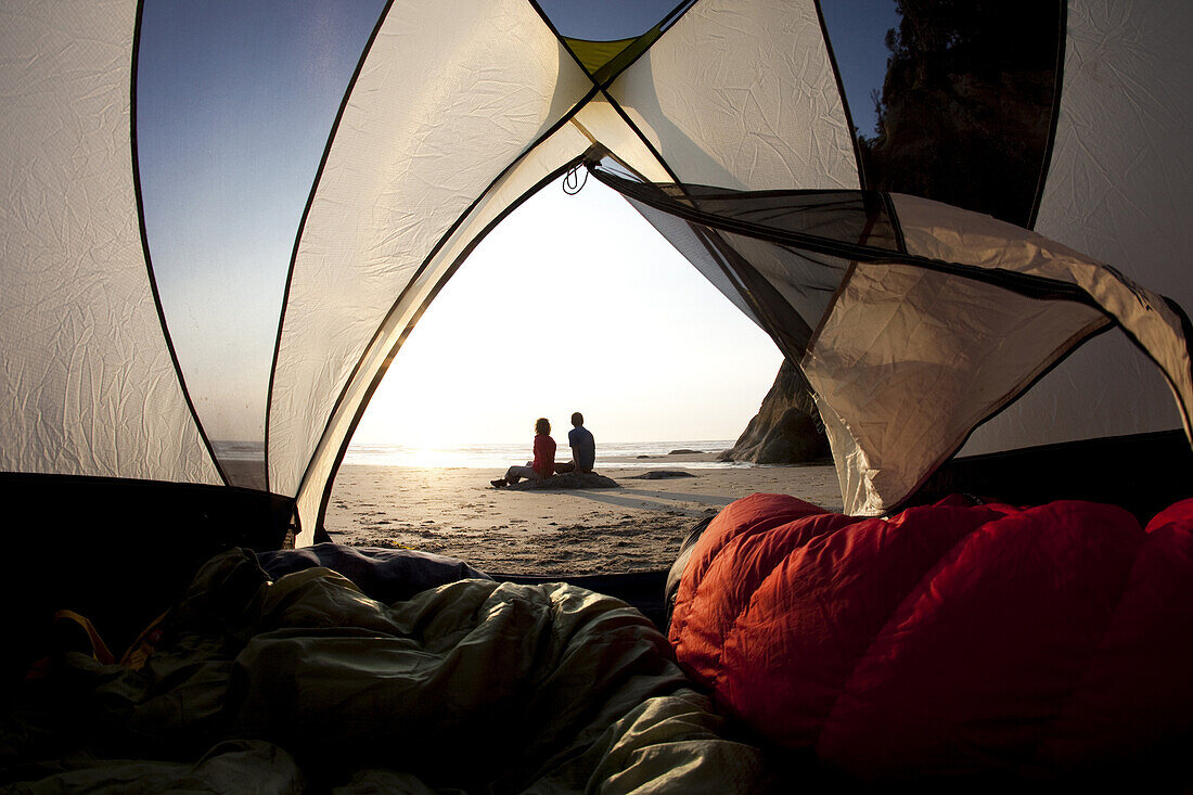 Maren Ludwig and Brad Hill watching the sunset while camping at Hug Point on the Oregon Coast.