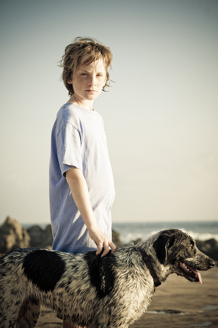 A portrait of Aidan Steele, age 12, and his dog named Mancha Spot, at sunset on a quiet beach in Troncones, Mexico on March 31, 2009.
