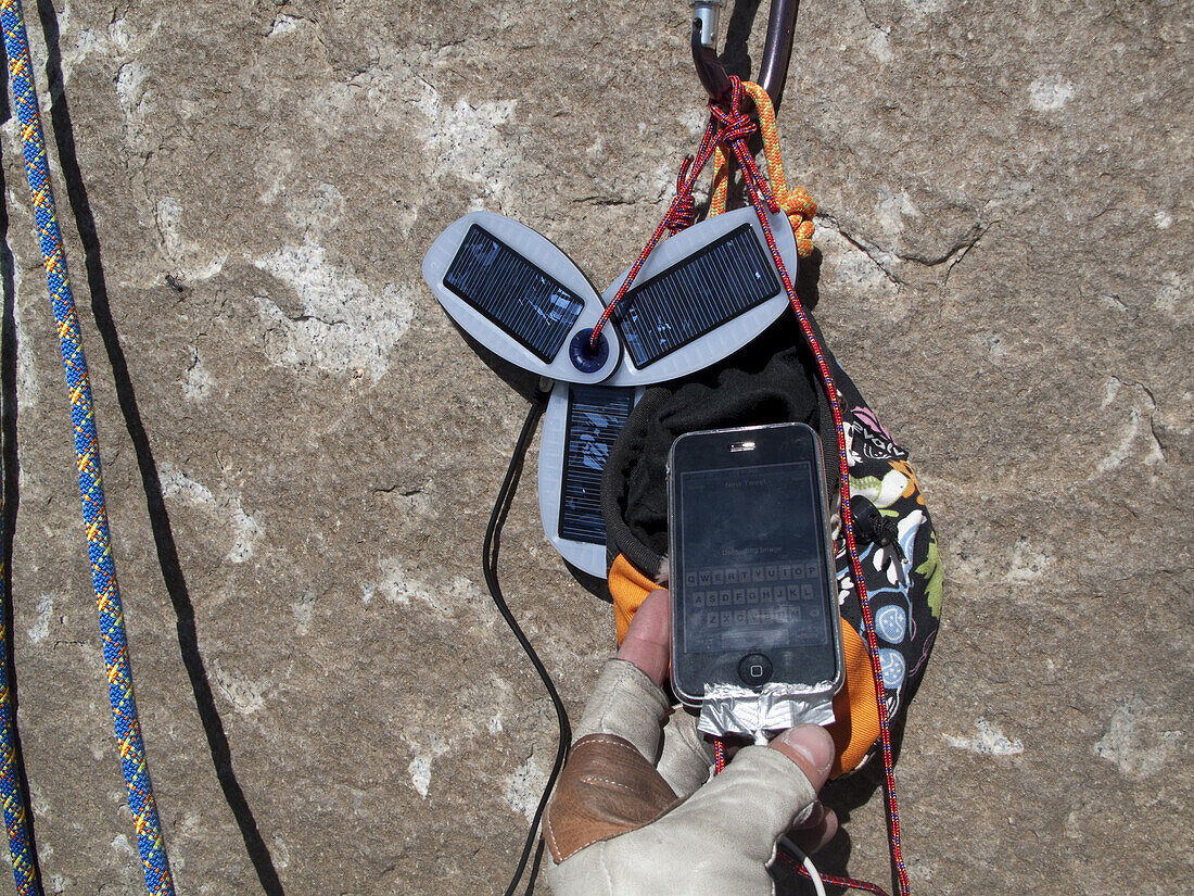 Closeup of a Solio solar charger hanging at a belay while bigwall climbing on El Capitan in Yosemite Valley, CA, USA. This  charger was used to power an iPhone.