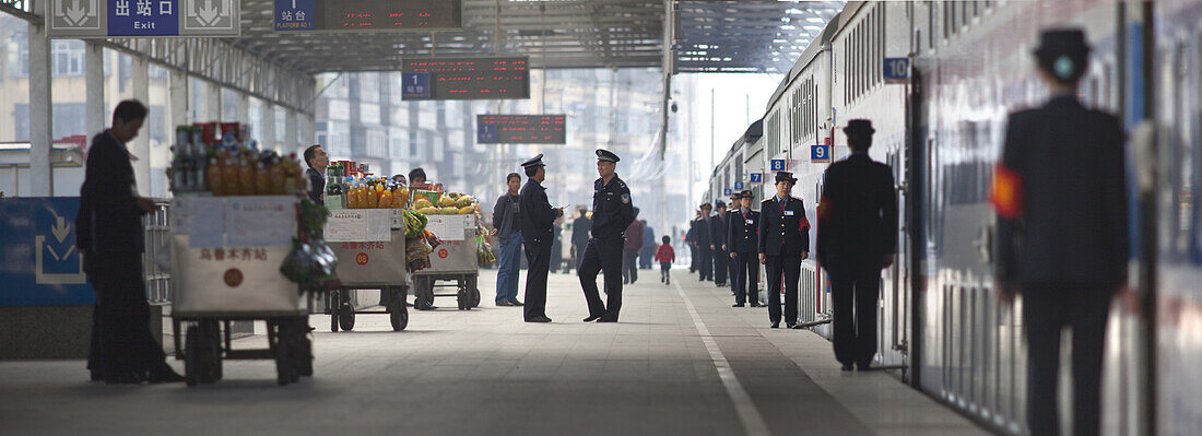 Urumqi, China - September 22, 2009: Attendants neatly lined up on a train platform in Urumqi.