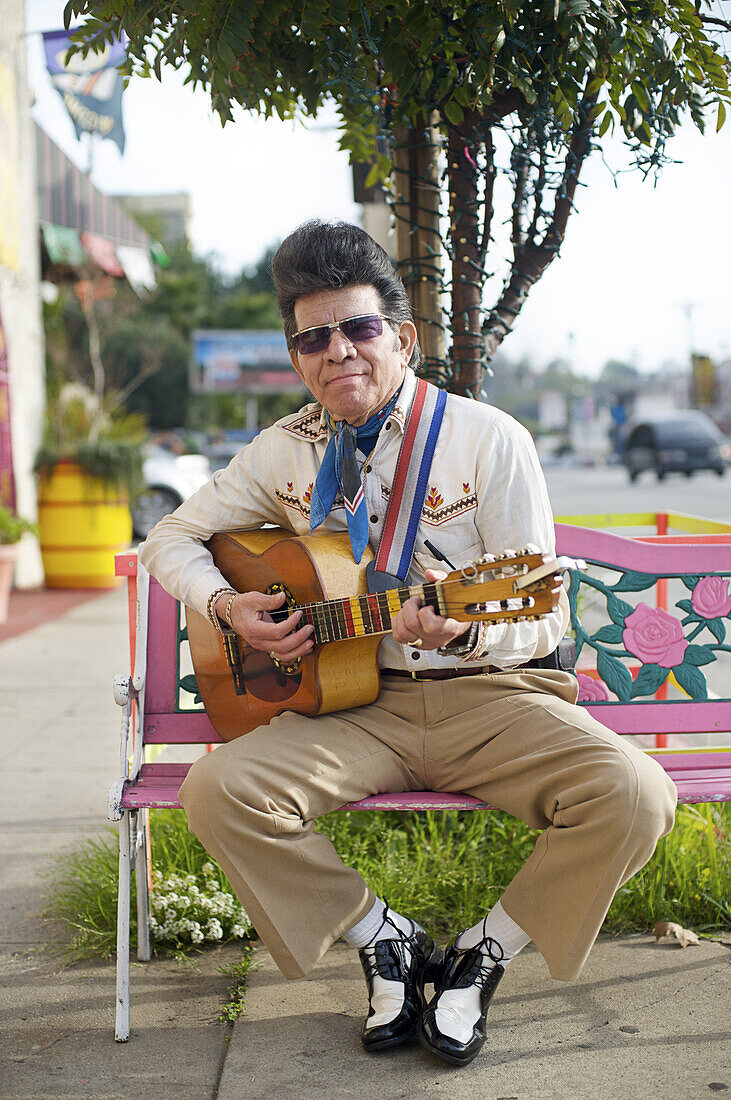 'Raphael ''Elvis'' Coca, originally of San Salvador, sits outside the La Parilla restaurant where he works, in Silver Lake, Calif., on Sunday, Jan. 31, 2010. He works in the restaurant as a performer.'