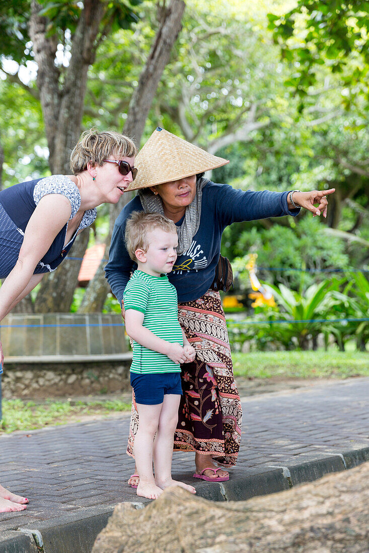 Balinese women, German mother with son, 3 year old boy, showing, playing, intercultural, meeting local people, locals, family travel in Asia, western baby, parental leave, MR, Sanur, Bali, Indonesia
