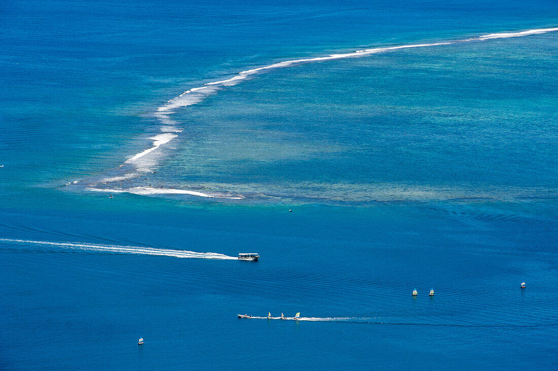 People enjoying watersports along a reef near Cook's Bay, Moorea, French Polynesia, South Pacific