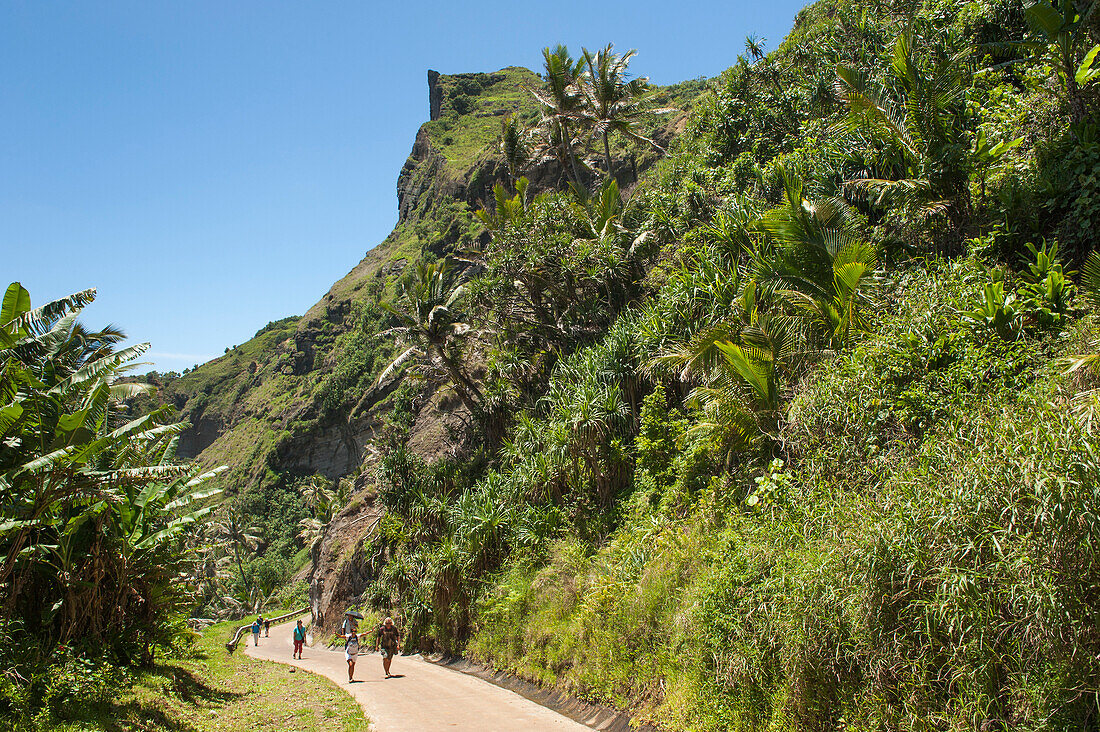 Menschen laufen auf einer Straße durch den tropischen Wald, Pitcairn, Pitcairninseln, Britisches Überseegebiet, Südpazifik
