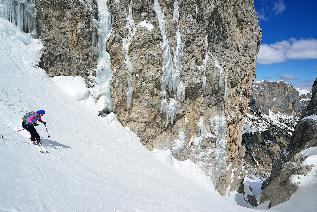 Female back-country skier skiing downhill through Val Setus, Sella Group, Dolomites, South Tyrol, Italy