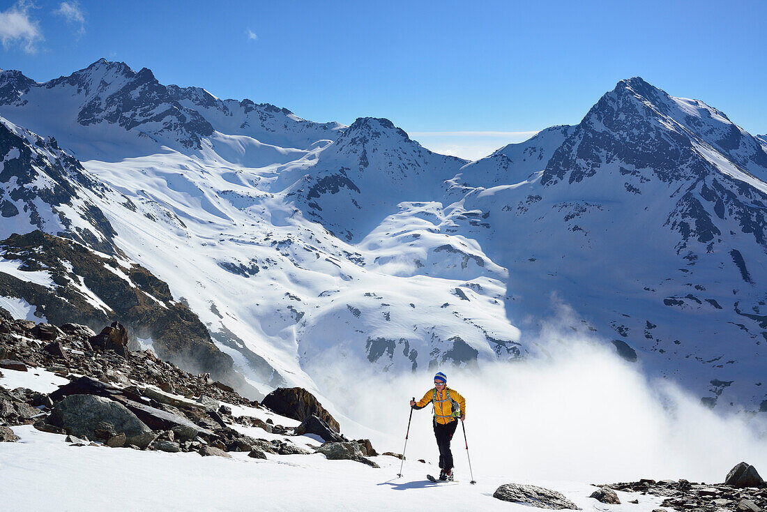 Frau auf Skitour steigt zum Piz Buin auf, Hintere Jamspitze und Piz da las Clavigliadas im Hintergrund, Silvretta, Unterengadin, Engadin, Kanton Graubünden, Schweiz