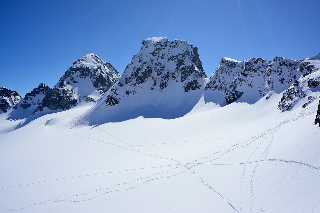 Tracks in snow, Great Piz Buin and Piz Buin Pitschen in background, Silvretta Range, Lower Engadin, Engadin, Canton of Graubuenden, Switzerland