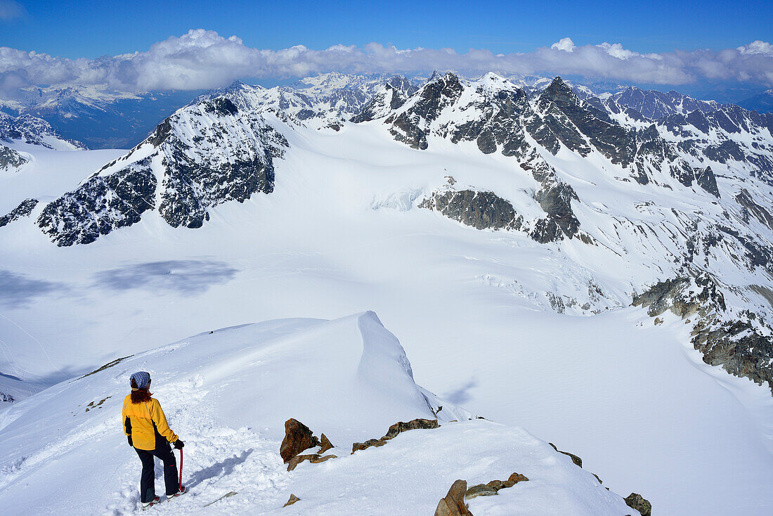 Frau auf Skitour steigt vom Gipfel des Piz Buin ab, Silvrettahorn, Schneeglocke und Schattenspitze im Hintergrund, Silvretta, Unterengadin, Engadin, Graubünden, Schweiz