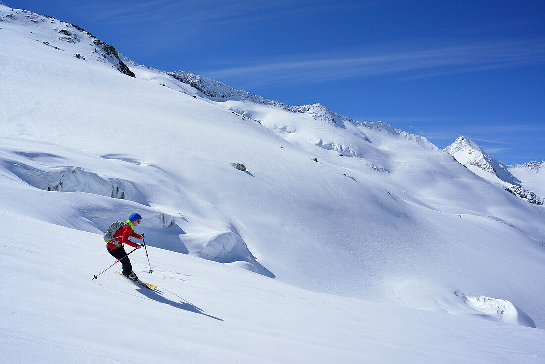 Female back-country skier downhill skiing from Grossvenediger, Venediger Group, High Tauern National Park, Salzburg, Austria