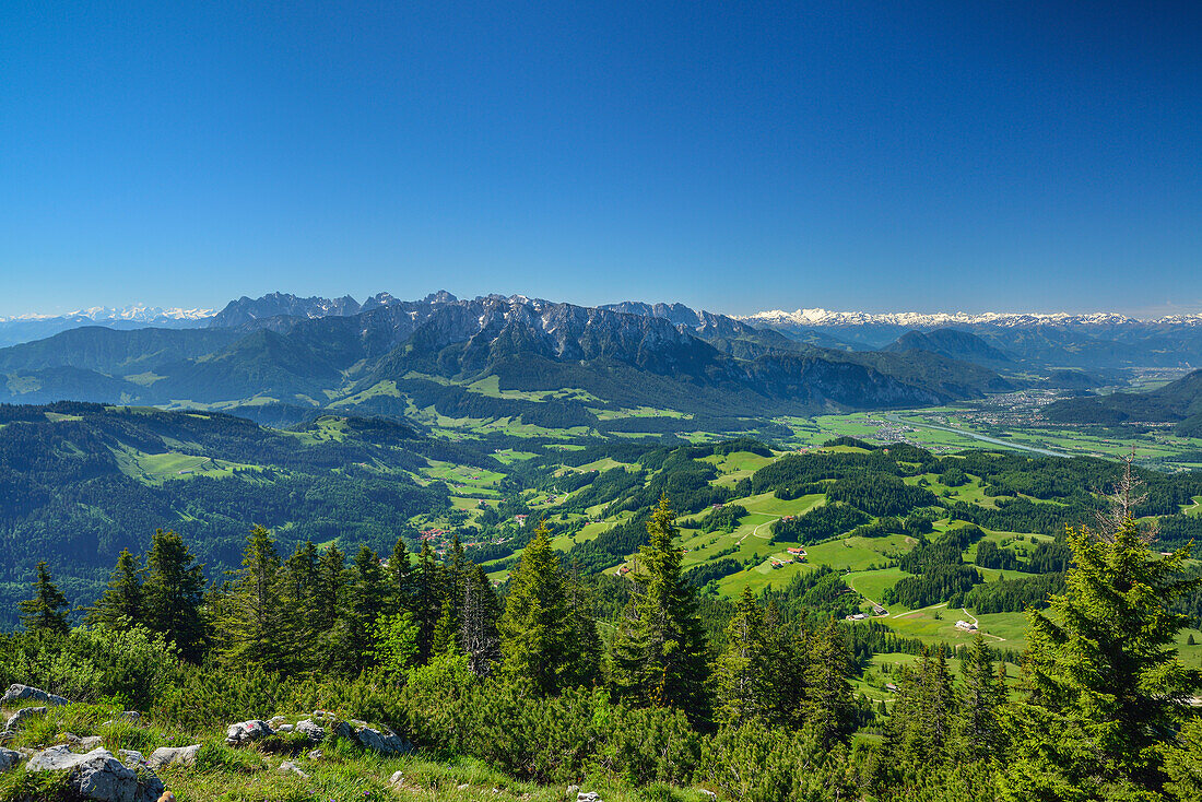 View over alpine meadows and Inn Valley, Kaiser Mountain Range and Zillertal Alps in background, Spitzstein, Chiemgau Alps, Tyrol, Austria