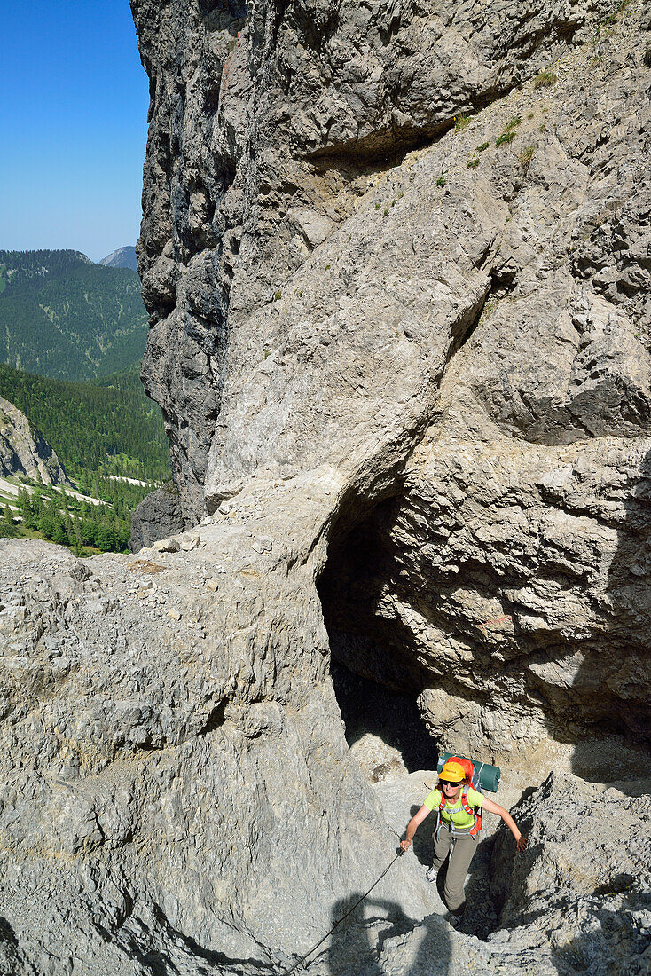 Frau beim Wandern steigt durch Felsentor ab, Schinderkar, Schinder, Bayerische Voralpen, Oberbayern, Bayern, Deutschland